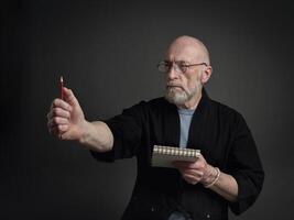 senior man in kimono making sketches photo