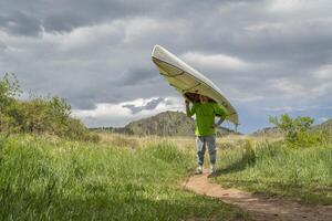 senior male is portaging expedition canoe photo