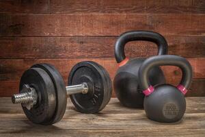 cast iron dumbbell and kettlebells on deck photo