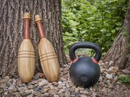pair of wooden Indian exercise clubs and iron kettlebell photo