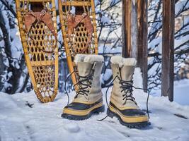 pesado nieve botas y clásico de madera raquetas de nieve foto