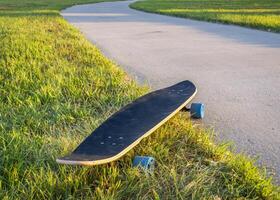 cruising longboard with blue wheels on a paved bike trail in summer scenery in northern Colorado photo