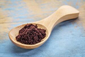 acai berry powder on wooden spoon photo