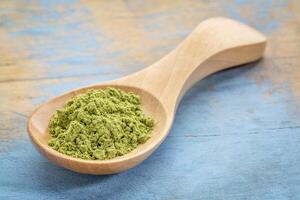 moringa powder on wooden spoon photo