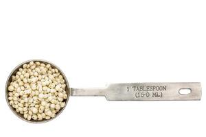 sorghum grain in a tablespoon photo