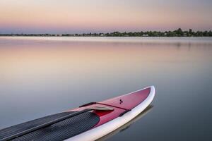 estar arriba paddleboard en lago foto