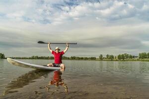 senior paddler on stand up paddleboard photo