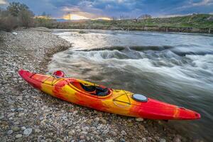 whitewater kayak and river rapid at sunset - Cache la Poudre River in Fort Collins, Colorado photo