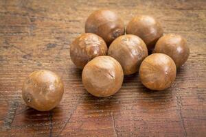 macadamia nuts on rustic wood photo