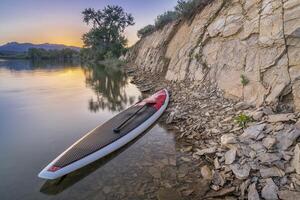 estar arriba paddleboard en lago foto