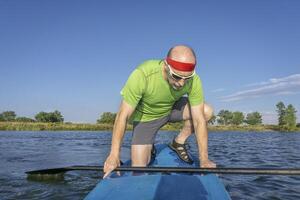 mayor masculino palista en paddleboard foto