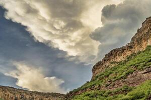 dramatic louds over cliff photo