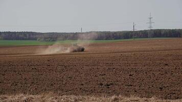 tractor cultivator or seeder plows the land, prepares for crops. dust on field video