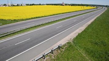 traffic on the highway against the backdrop of a blooming rapeseed field video