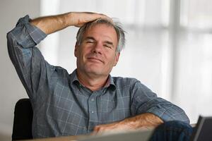 Content middle-aged man enjoying a peaceful moment at his desk during a workday photo