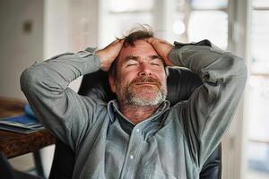 Content middle-aged man enjoying a peaceful moment at his desk during a workday photo