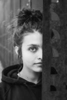 White brunette teenage girl with curly hair poses on the street in the city. photo