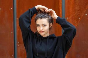 White brunette teenage girl with curly hair poses on the street in the city. photo