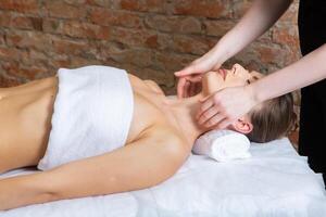 joven mujer consiguiendo un espalda masaje en un spa salón. belleza tratamiento concepto. foto