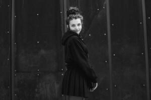 White brunette teenage girl with curly hair poses on the street in the city. photo