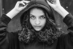 White brunette teenage girl with curly hair poses on the street in the city. photo