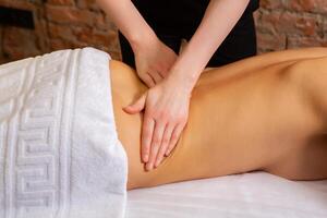 Young woman getting a back massage in a spa salon. Beauty treatment concept. photo