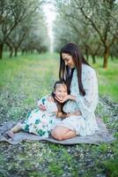 A happy family. Mother and daughter rest in the park in dresses photo