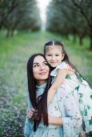 A happy family. Mother and daughter rest in the park in dresses photo