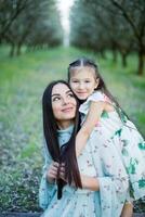 A happy family. Mother and daughter rest in the park in dresses photo