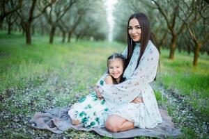 A happy family. Mother and daughter rest in the park in dresses photo