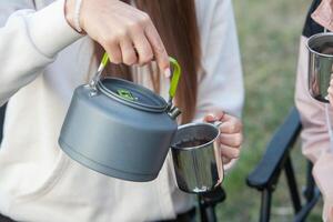 Portrait of a beautiful young woman with cup of tea outdoors. photo
