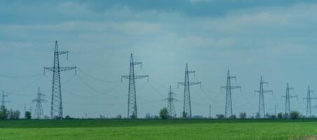 High voltage towers with sky background. Power line support with wires for electricity transmission. High voltage grid tower with wire cable at distribution station. Energy industry, energy saving photo