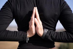 A person is praying with their hands clasped together photo