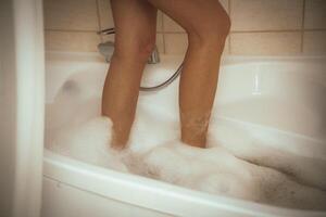 Women's feet in bath foam. View from above. Enjoy and relax in a spa hotel photo