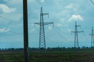 alto voltaje torres con cielo antecedentes. poder línea apoyo con alambres para electricidad transmisión. alto voltaje cuadrícula torre con cable cable a distribución estación. energía industria, energía ahorro foto