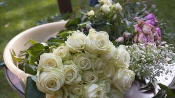 professionell blomsterhandlare arbetstagare dekorerar festlig båge för ceremoniell äktenskap registrering. kvinna montera bröllop dekor. dekoratör dekorera båge utomhus- bröllop ceremoni med blommor och grönska. video