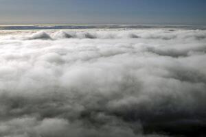 Sunrise clouds carpet view from airplane window while flying photo