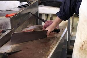 detalle de mano de un pescadero el cortar espadachín a Fresco pescado Mariscos a Ortigia Siracusa Sicilia pescado mercado Italia foto