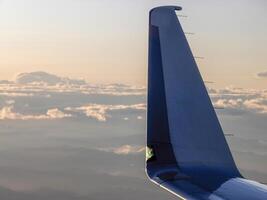 airplane wing detail flying at sunrise photo