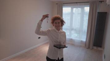 femme réel biens agent permanent dans vide maison avec clés dans main. femme vente propriété. professionnel agent immobilier. concept de vente et location appartements. propriété courtier offre propriétés. video