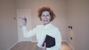 femme réel biens agent permanent dans vide maison avec clés dans main. femme vente propriété. professionnel agent immobilier. concept de vente et location appartements. propriété courtier offre propriétés. video