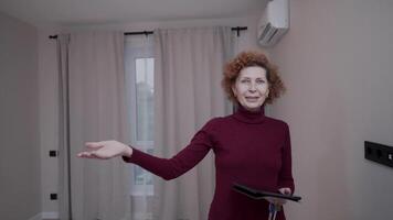 Mature female real estate agent shows apartment. A salesman property manager at a showing of a residential property. Property investment. Agent demonstrating a new apartment. Home rentals and sales. video