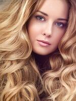 Beautiful modern blonde woman with volume hairstyle, long luxurious hair and beauty makeup, glamorous look face portrait for luxury fashion and natural cosmetics photo