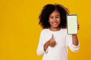 alegre africano americano niña demostrando teléfono inteligente con blanco pantalla y pulgares arriba en soleado amarillo antecedentes foto