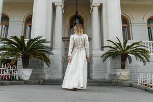 a woman in a flower dress go to opens the door to the house photo