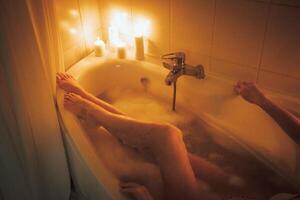 Women's feet in bath foam. View from above. Enjoy and relax in a spa hotel photo