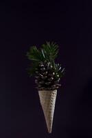 A cone shaped ice cream cone with pine needles on top photo