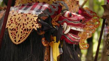 Flying fox sitting on an Asian animal mask sculpture, bats hanging upside down video