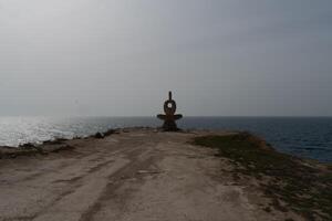 Sculpture symbol made of large pebbles against the blue sky photo