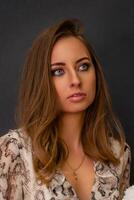 Portrait of a beautiful young business woman standing against grey background photo